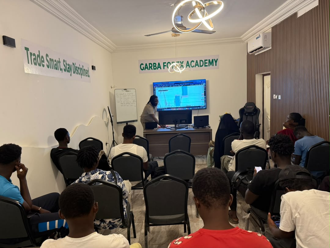 Wide view of the Garba Forex Academy classroom with academy branding